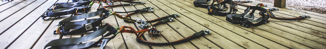 accrobranche plateforme avec les équipements nécessaires à l'activité : baudriers, mousquetons.